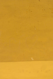 a man riding a skateboard down a street next to a yellow wall