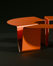 Orange, modern side tables are on display.